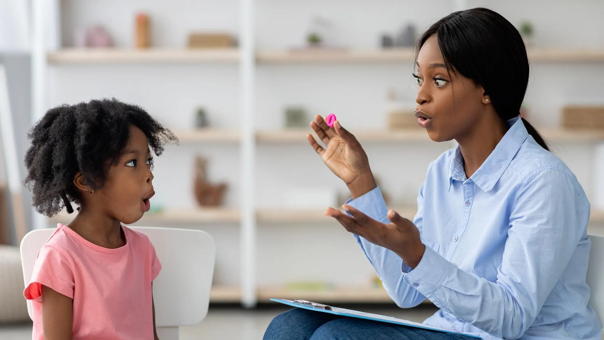 a little girl learn read a letter with her teacher
